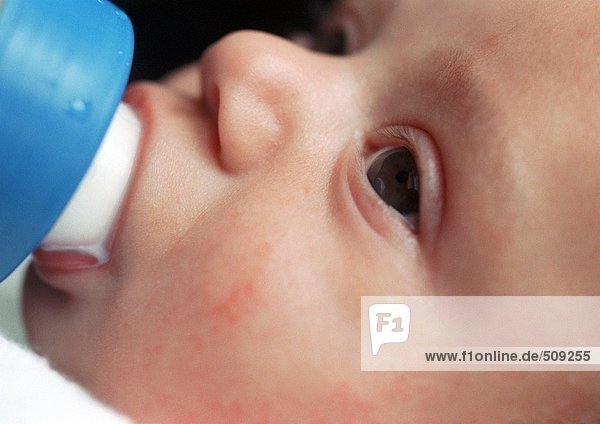 Baby's face  drinking from bottle  close-up