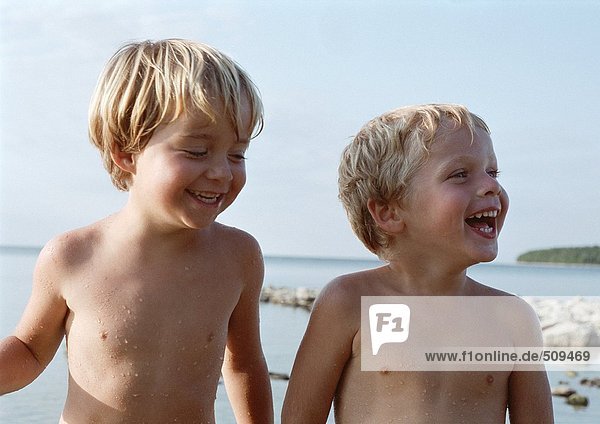 Nackte Kinder lächeln  Meer im Hintergrund