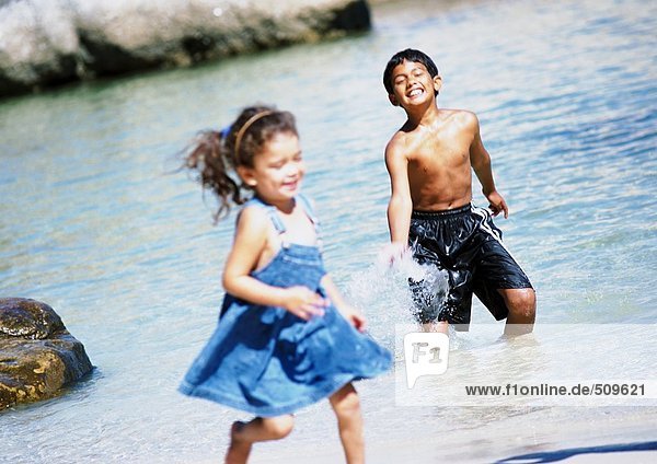 Junge und Mädchen im Wasser  Junge plantschend  Mädchen rennend