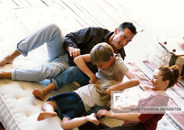 Eltern und Kinder beim Spielen auf der Matratze