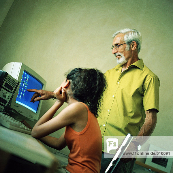 Senior Mann und Mädchen  die auf den Computer schauen