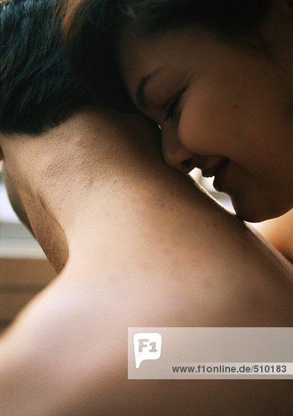 Woman's face against man's bare neck  close-up