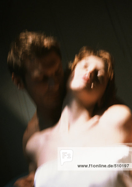 Man embracing woman from behind  close-up  blurred