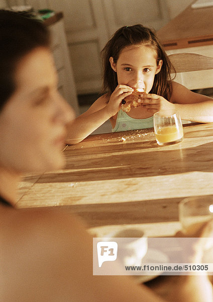 Mädchen beim Essen am Tisch mit Mutter