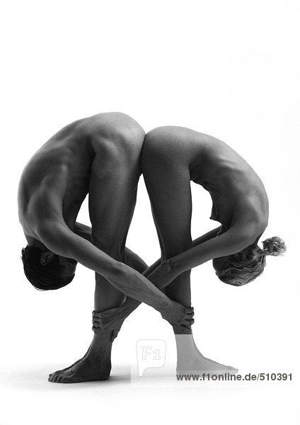 Nackter Mann und Frau Rücken an Rücken  sich nach vorne beugen  sich gegenseitig die Knöchel halten  s/w