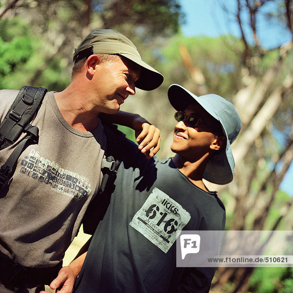 Teenage boy and man hiking  side by side