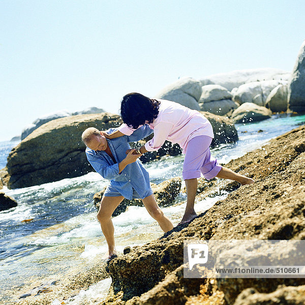 Couple playfighting on rocks