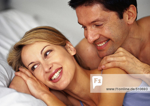 Couple in bed  smiling  close-up