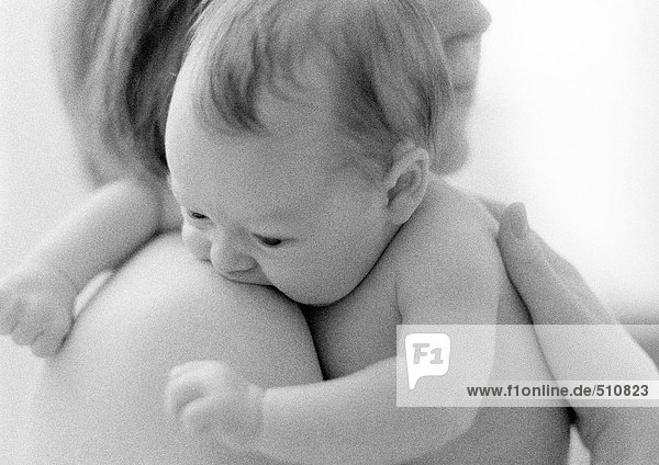 Mutter hält Kleinkind auf nackter Schulter  s/w