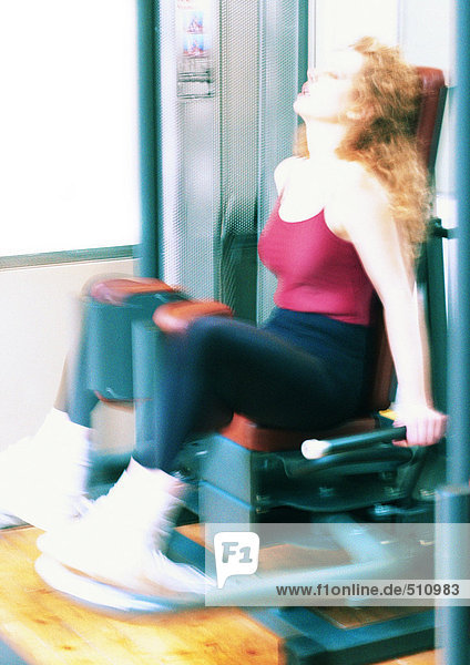 Frau mit Gewichtsmaschine im Fitnessstudio