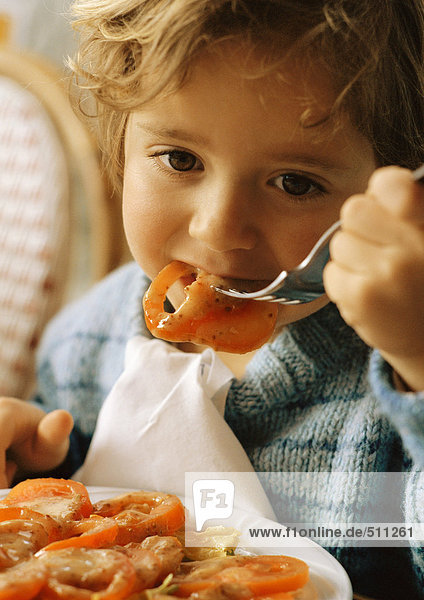 Kind isst Tomatenscheiben  Porträt.