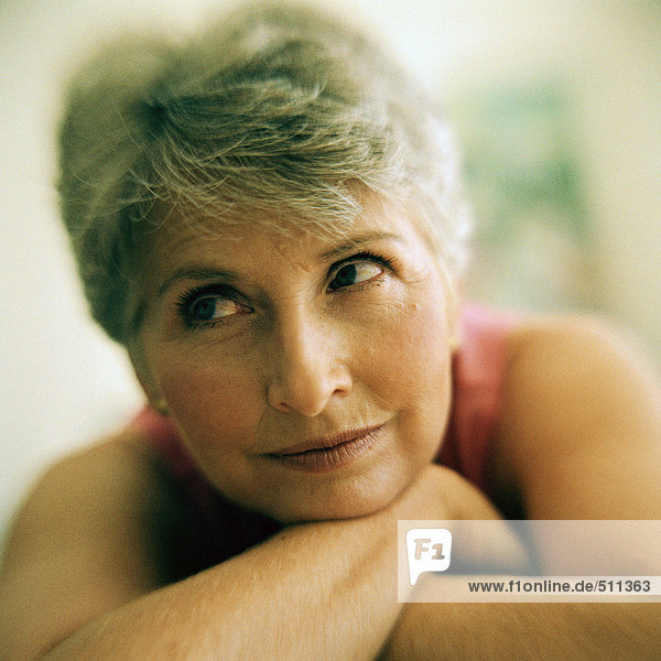 Portrait of mature woman arms crossed under chin  close-up