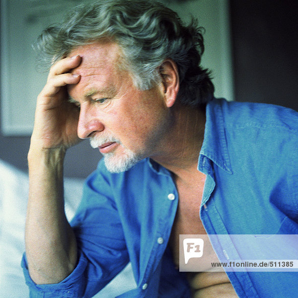 Profile of man with pensive expression and hand on forehead