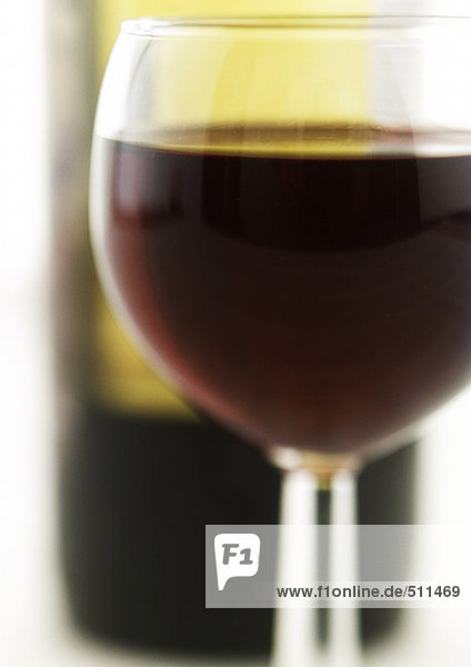 Glas Rotwein  Flasche im Hintergrund