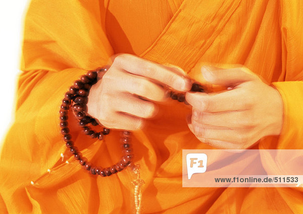 Buddhistische Mönchshände mit Gebetsperlen