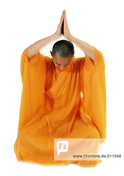 Buddhistischer Mönch beim Meditieren mit den Händen über dem Kopf