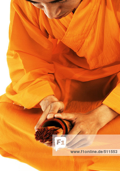 Buddhistischer Mönch meditiert  hält Devotionalien in der Hand