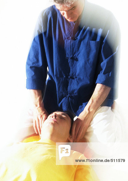Massagetherapeutin beim Massieren des Männerkopfes