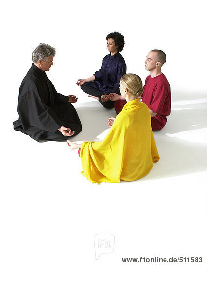 Menschen  die auf dem Boden in Lotusstellung sitzen und meditieren.