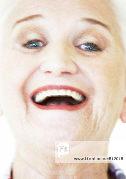 Senior woman smiling at camera  portrait  close-up  blurred