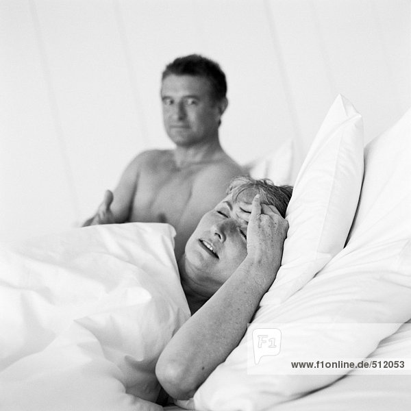 Erwachsenes Paar im Bett,  Frau mit Kopfhaltung
