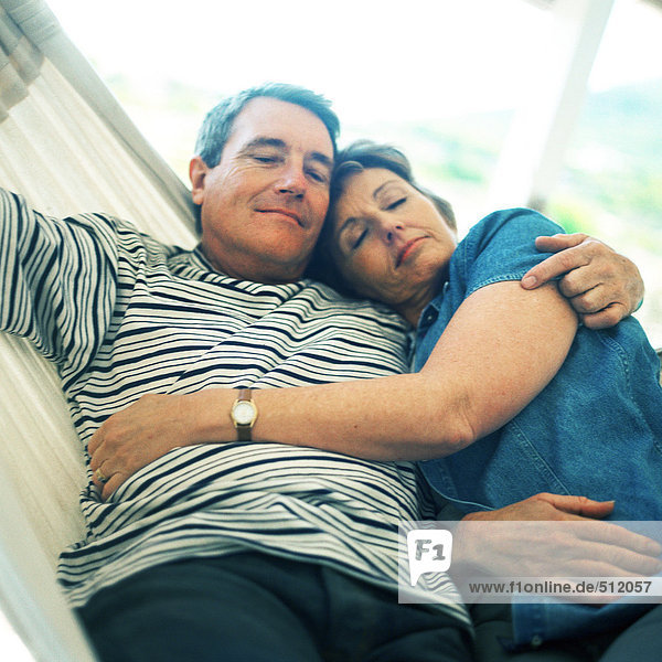 Mature couple lying in hammock