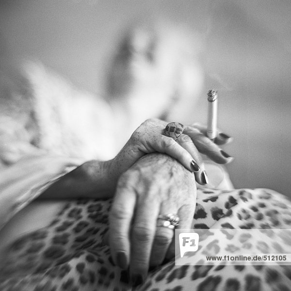 Reife Frauenhände mit Zigarette  niedrigem Blickwinkel  s/w