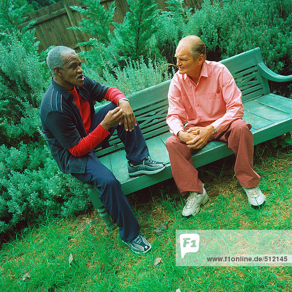 Zwei reife Männer sitzen auf der Bank.