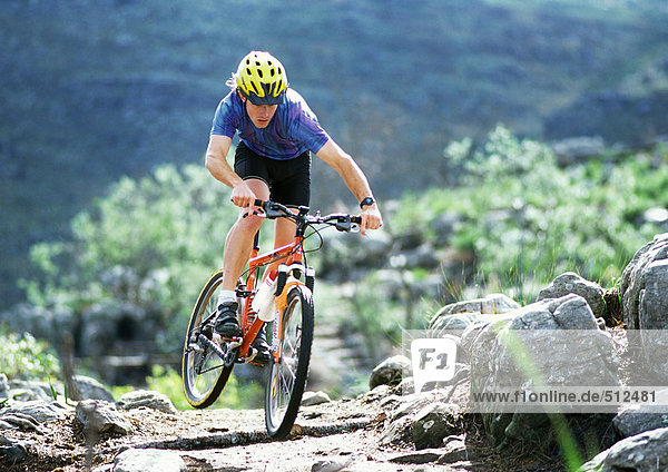 Young man on mountain bike  riding on mountain trail.