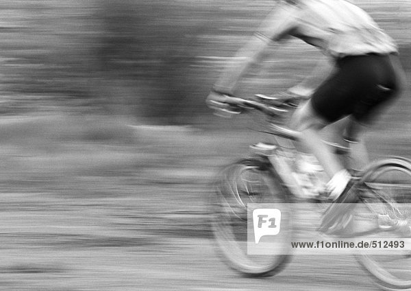 Man cycling  side view  blurred  b&w.