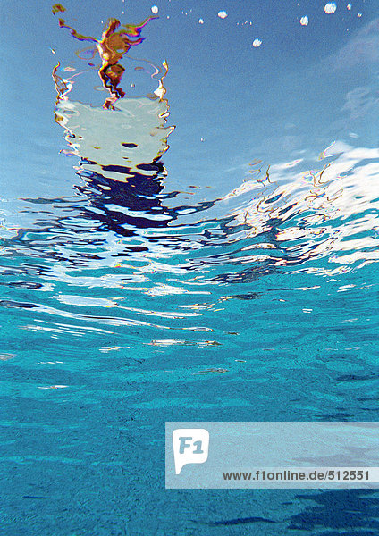 Person standing on diving board about to dive  underwater view.