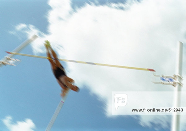 Male pole vaulter in mid-air  blurred motion