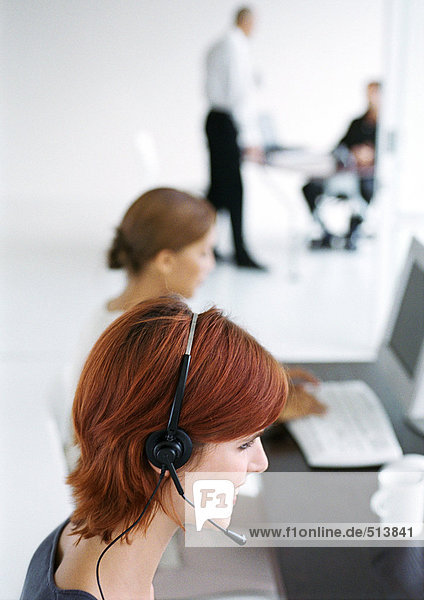 Frau im Büro  Headset tragend  verschwommen