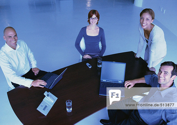 Business people around desk  smiling  elevated view