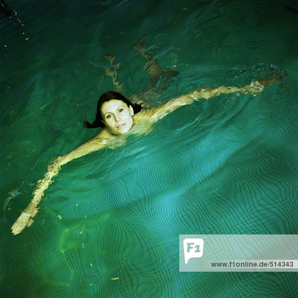 Frau schwimmt im Pool  erhöhte Aussicht