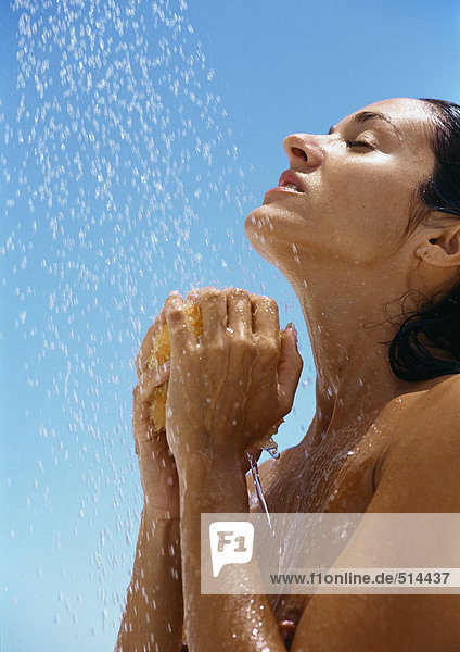 Frau unter der Dusche  Hände unter dem Kopf mit Schwamm  Seitenansicht  Nahaufnahme