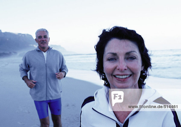 Mature man and woman in sportswear on beach
