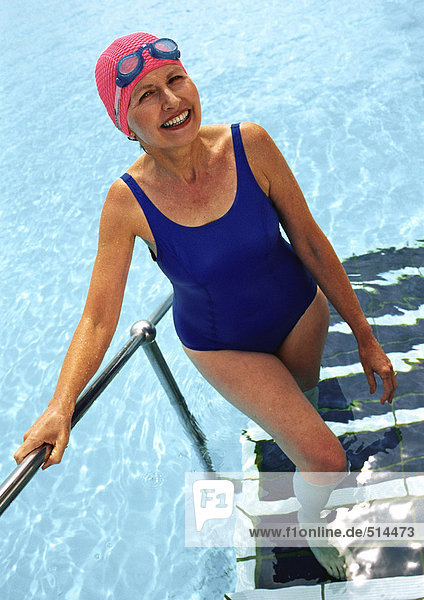 Reife Frau  die aus dem Schwimmbad kommt und lächelt.