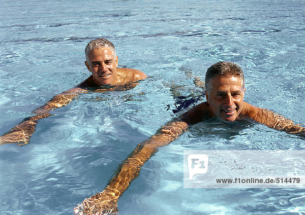 Two mature men in swimming pool  smiling