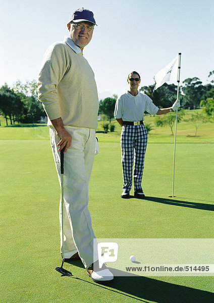 Two mature golfers on green  portrait