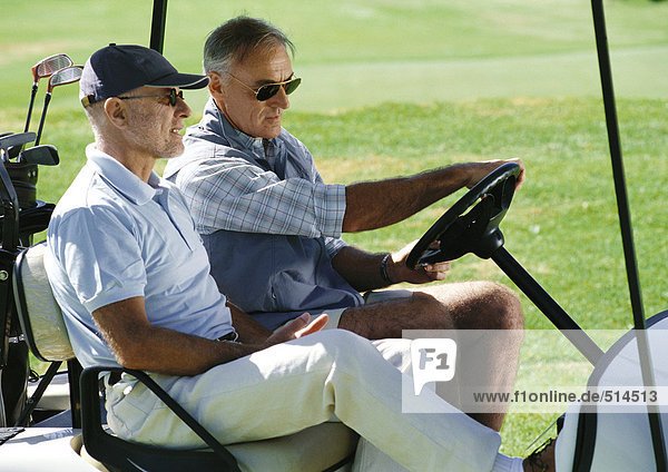 Zwei reife Golfer im Golfwagen  Nahaufnahme  Seitenansicht