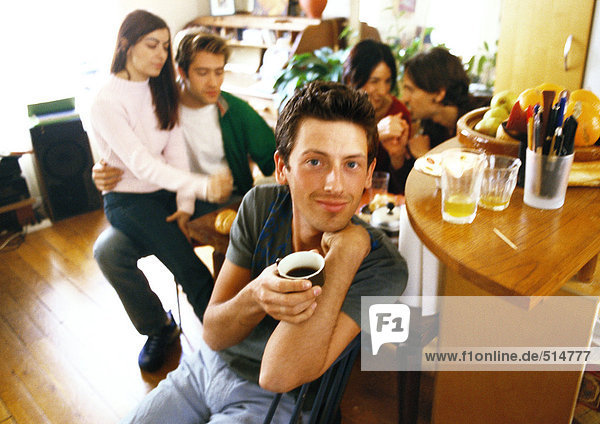 Young people in living room  man having coffee