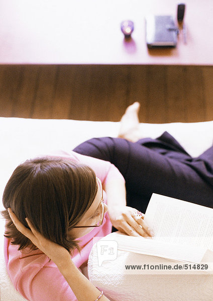 Woman lying and reading book