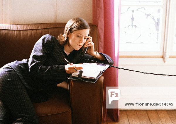 Woman on phone looking at agenda