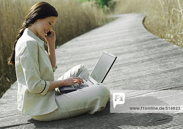 Geschäftsfrau sitzend mit Laptop  im Freien