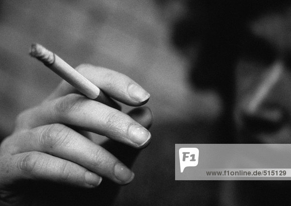 Frauenhand hält Zigarette  Nahaufnahme  verschwommen  s/w