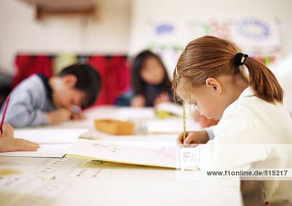 Kinder sitzen am Tisch  schreiben
