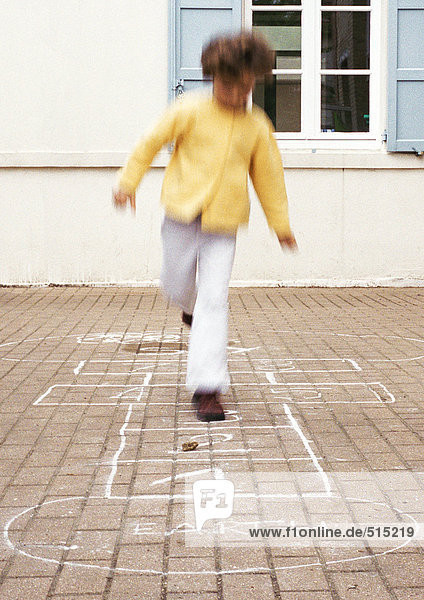 Kind spielt Hopscotch