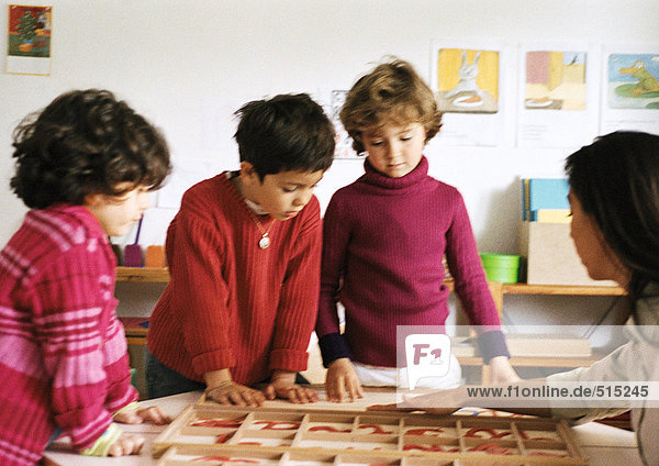 Three children listening to teacher