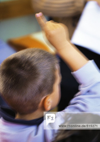 Kind legt Finger hoch  Kopf und Schultern  Rückansicht  unscharf